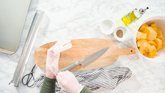 Flat lay. Cutting butternut squash on a wood cutting board.