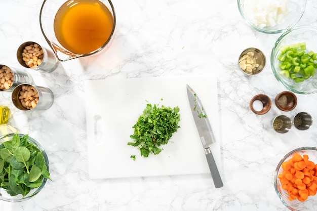 Flat lay Cutting organic parsley on a white cutting board