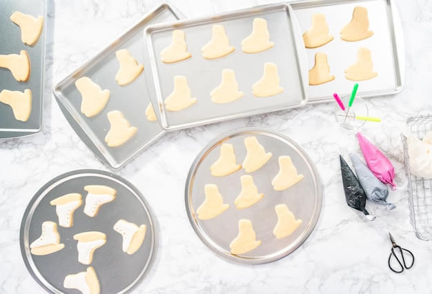 Photo flat lay. decorating sugar cookies shaped as figure skates with royal icing.