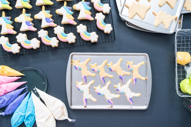 Flat lay. Decorating unicorn themed sugar cookies with royal icing.