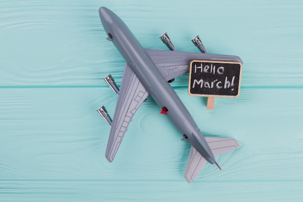 Flat lay design of travel concept with plane on blue background. Hurry up on nameplate.