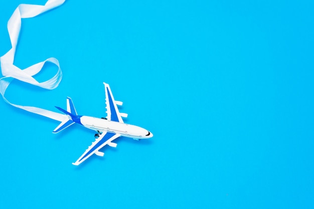 Design piatto laici del concetto di viaggio con aereo su sfondo blu con spazio di copia.