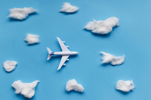 Photo flat lay design of travel concept with plane and cloud on blue