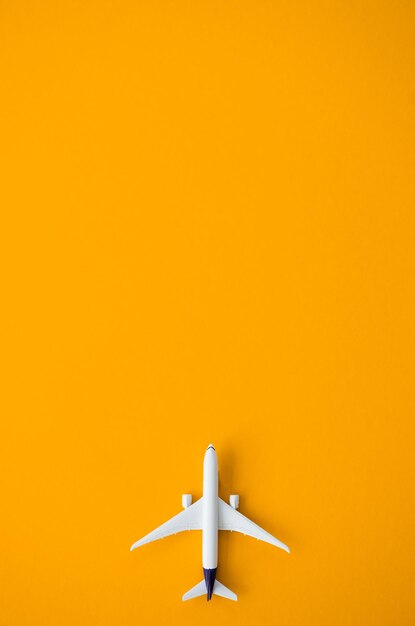 Flat lay design of travel concept with plane on yellow background