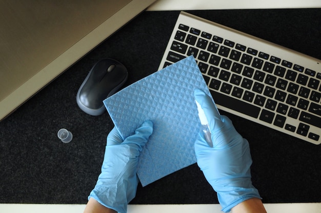 Flat lay of desinfecting devices at home. Preventing disease by sanitazing keybord, mouse and laptop