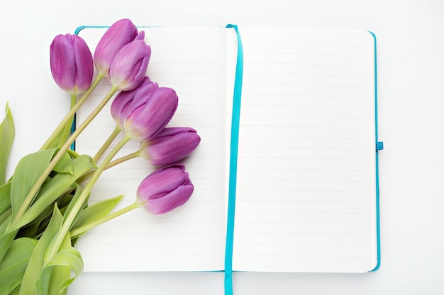 Flat lay desk with notebook and flowers