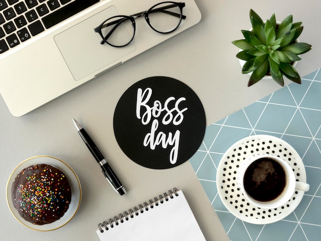 Flat lay desk with sign for boss day