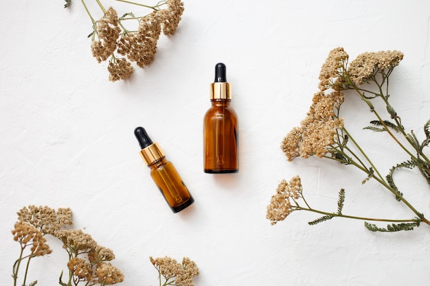 Photo flat lay of dropper glass bottle skincare essential oil products for mock up in minimal style with on white background.