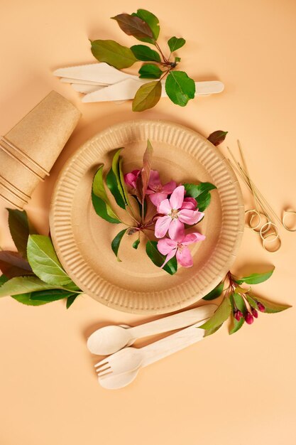 Flat lay of eco craft paper tableware with flowers Zero waste plastic free