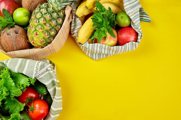 Flat lay of eco friendly grocery shopping cotton bags with organic fruits and vegetable