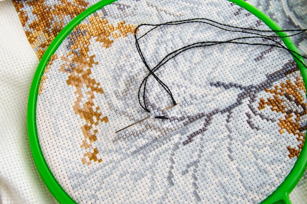 Flat lay embroidery Hoop with canvas and bright sewing thread and embroidery needle