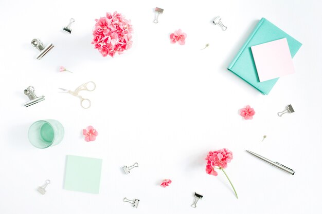 Flat lay fashion office desk. Female frame workspace with red flowers, accessories, mint diary on white