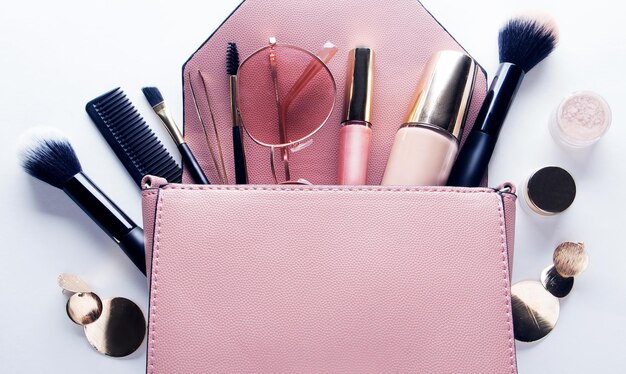 Flat lay of female fashion accessories and pink handbag on white background with copyspace