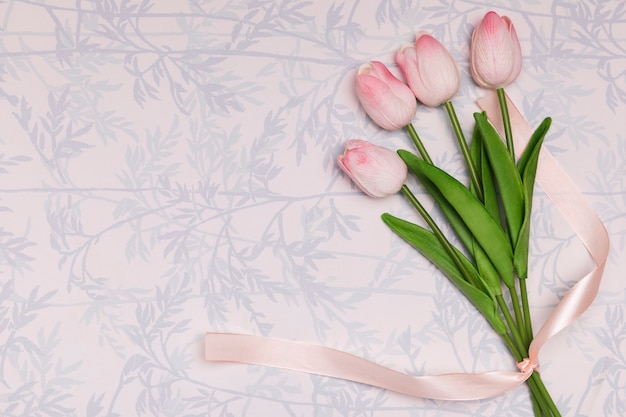 Cornice piatta laica con tulipani su sfondo floreale