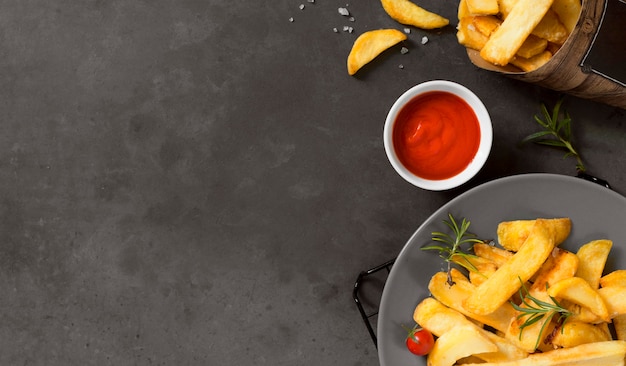 Flat lay of french fries on plate with ketchup and copy space