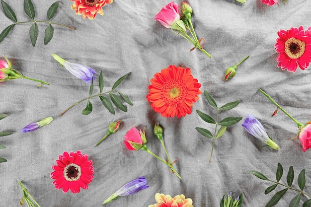 Плоская планировка свежих цветов на текстильном фоне