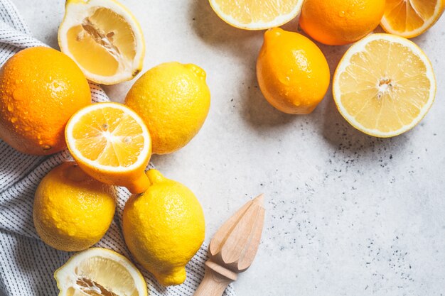 Flat lay of fresh lemons for juice on gray background.