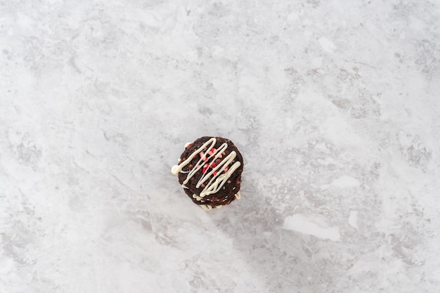 Flat lay. Freshly baked chocolate cookies with peppermint chips with a white chocolate drizzle on top.