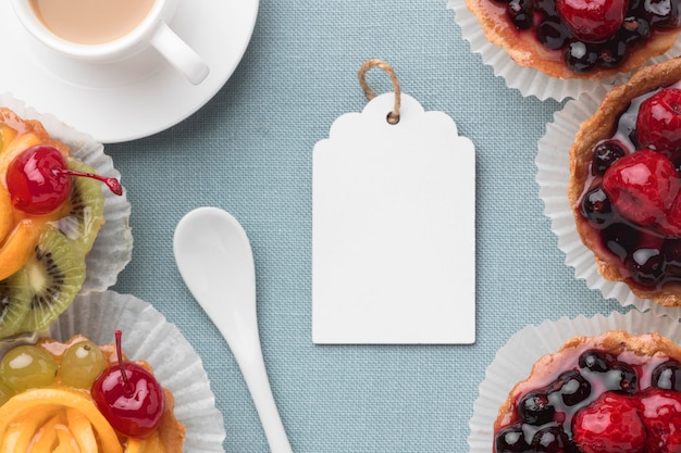 Photo flat lay of fruit tarts with tag and coffee