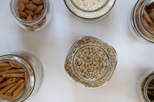 Flat lay of glass jars with food on white background