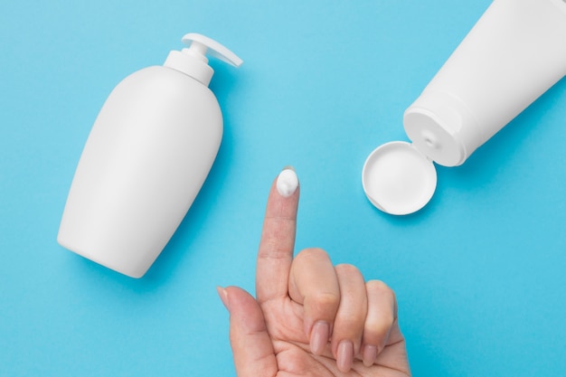 Photo flat lay of hand with hydro alcoholic gel bottle