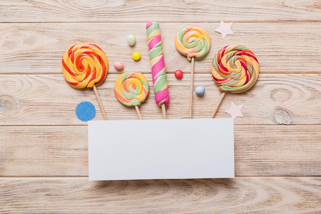 Flat lay holiday composition Paper blank lollipop birthday decorations on Colored background Top view copy space for text