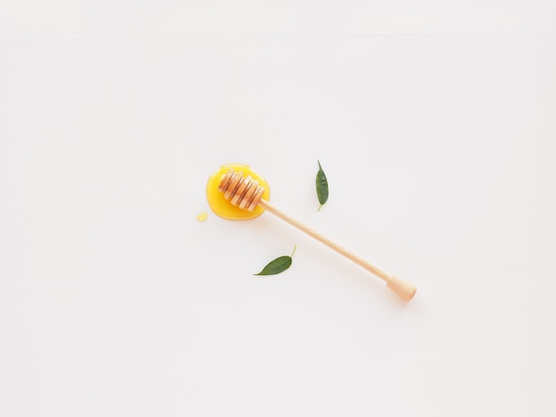 Flat lay honey with dipper and leaves