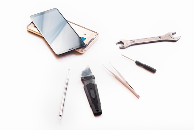 Flat lay image of dismantling the broken smart phone for preparing to repair or replace some components isolated