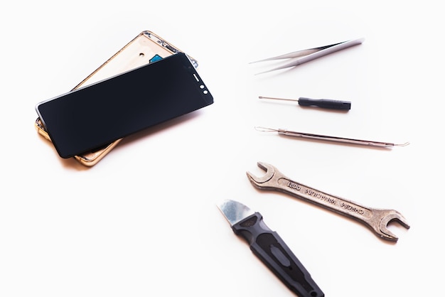 Flat lay image of dismantling the broken smart phone for preparing to repair or replace some components isolated