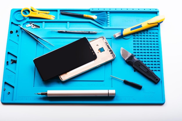 Flat lay image of dismantling the broken smart phone for preparing to repair or replace some components Top view