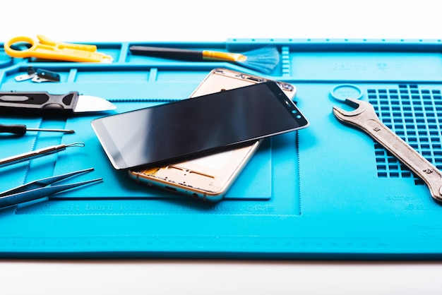 Photo flat lay image of dismantling the broken smart phone for preparing to repair or replace some components top view