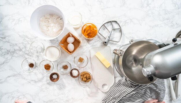 Flat lay. Ingredients to bake pumpkin spice cupcake on a marble countertop.