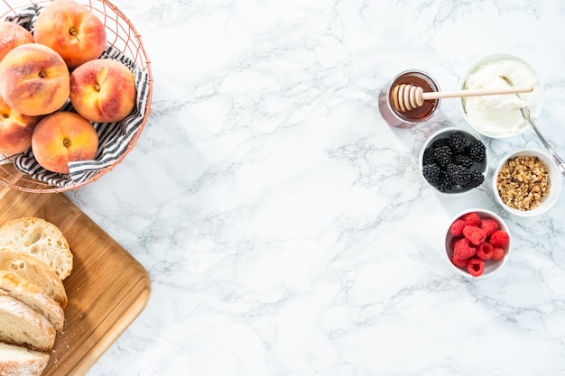 Flat lay. Ingredients for preparing peach ricotta toast on a marble countertop.