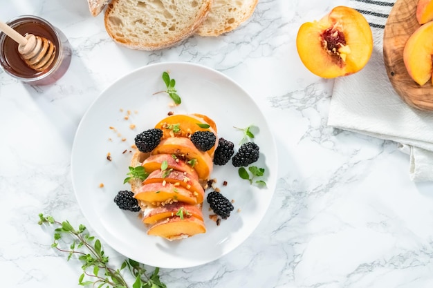 Flat lay. Ingredients for preparing peach ricotta toast on a marble countertop.