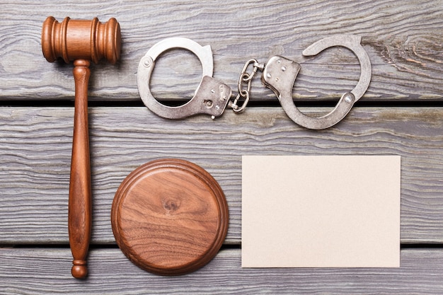 Flat lay justuce and court concept. Blank paper for copy space. Wooden gavel with handcuffs on the desk.