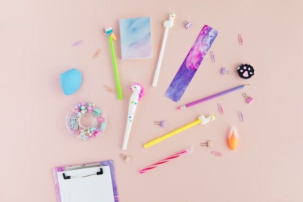 Flat lay of kawaii stylish school stationery on pink.