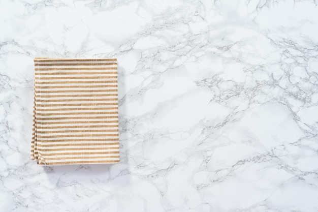 Flat lay. Kitchen towels with white and beige stripes on the marble counter.