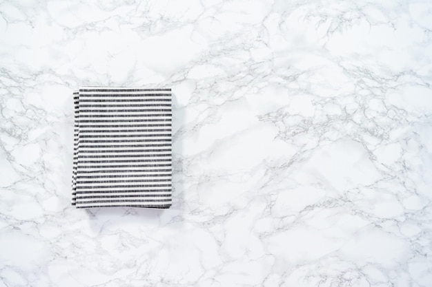 Flat lay. Kitchen towels with white and black stripes on the marble counter.