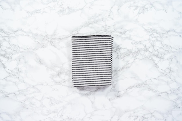 Flat lay. Kitchen towels with white and black stripes on the marble counter.