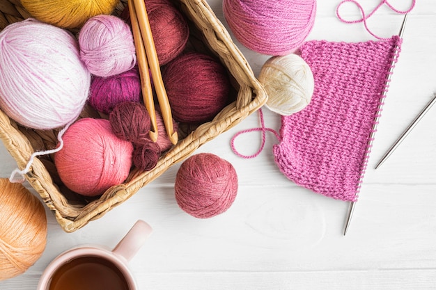 Flat lay of knitting set with yarn and basket