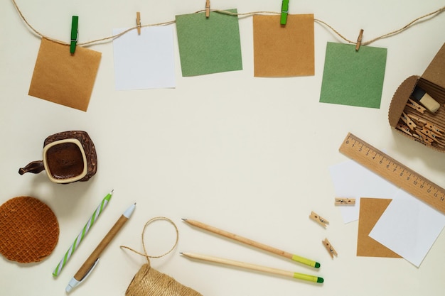 Flat lay of kraft paper stickers with clothespins, coffee and stationery