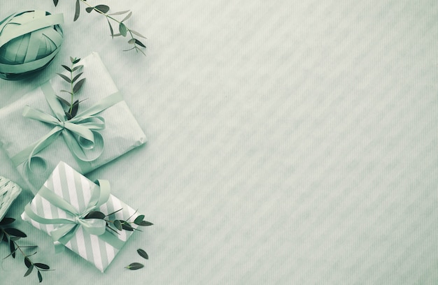 Flat lay in light blue with wrapped gift boxes decorated with eucalyptus twigs, copy-space