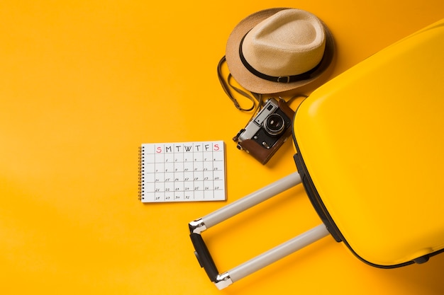 Photo flat lay of luggage with hat and travel essentials