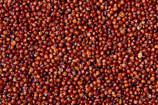 Photo flat lay macro natural dried red quinoa seeds top view close up texture background organic superfood rich in nutrients healthy food diet