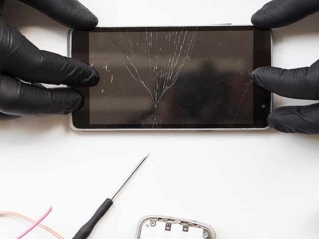 flat lay of man holding broken phone