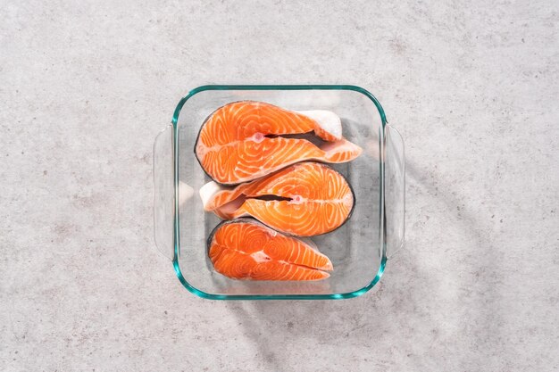 Flat lay Marinating salmon steaks in a glass dish for grilling