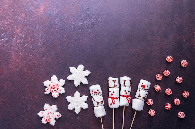 Flat lay. Marshmallow snowmen and raindeer on sticks for hot chocate drink.