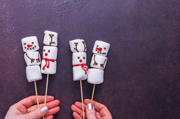 Photo flat lay. marshmallow snowmen and raindeer on sticks for hot chocate drink.