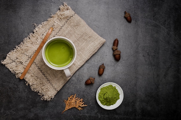 Flat lay of matcha tea in cup and acorns