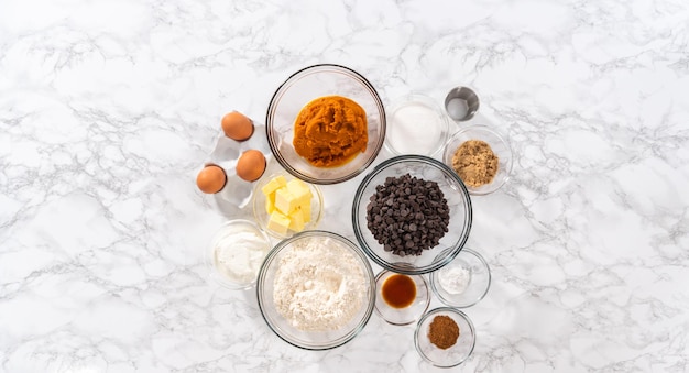 Flat lay. Measured ingredients in a glass mixing bowl to bake chocolate pumpkin bundt cake with toffee glaze.